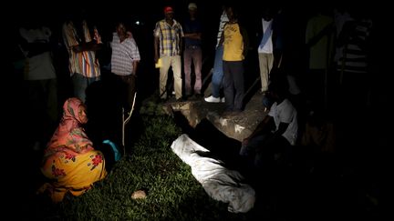 Des proches de&nbsp;Zedi Feruzi, le pr&eacute;sident de l'Union pour la paix et la d&eacute;mocratie (UPD), autour de son corps recouvert d'un drap, le 23 mai 2015 &agrave;&nbsp;Bujumbura (Burundi). (GORAN TOMASEVIC / REUTERS)