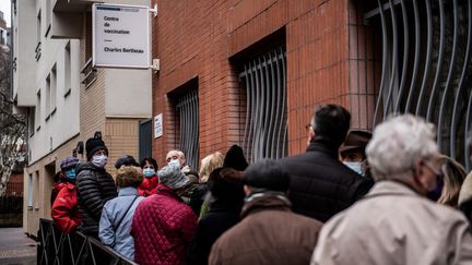 Des personnes patientent devant un centre de vaccination contre le Covid-19, le 15 janvier 2021 à Paris. (MARTIN BUREAU / AFP)