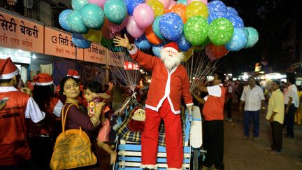 Une famille pose devant un p&egrave;re No&euml;l &agrave; Bombay (Inde), le 23 d&eacute;cembre 2014. (PUNIT PARANJPE / AFP)