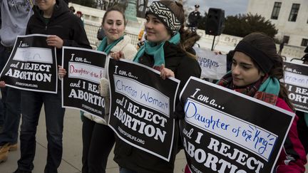 Des manifestantes "pro-vie" tiennent des pancartes où est écrit : "Je rejette l'avortement". (ZACH GIBSON / AFP)