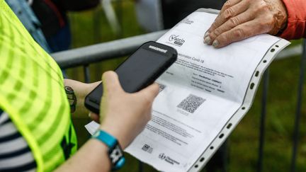 Un spectateur qui va assister au festival des Vieilles Charrues&nbsp;montre son pass sanitaire à l'entrée à&nbsp;Carhaix-Plouguer (Finistère), le 8 juillet 2021. (SAMEER AL-DOUMY / AFP)