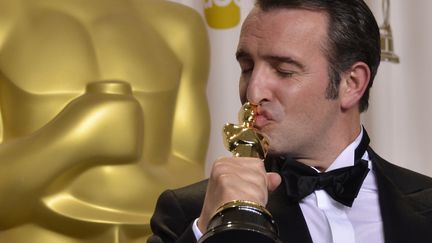 Jean Dujardin embrasse son Oscar du meilleur acteur re&ccedil;u dimanche 26 f&eacute;vrier &agrave; Los Angeles pour son r&ocirc;le dans "The Artist". (JOE KLAMAR / AFP)