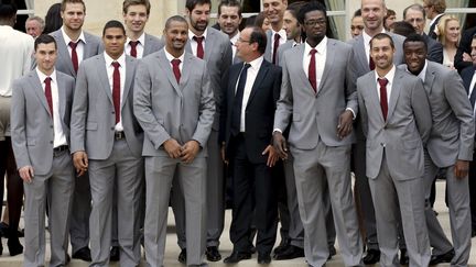 2012, les Experts viennent d'&ecirc;tre sacr&eacute;s aux Jeux olympiques de Londres. M&ecirc;me sur la marche sup&eacute;rieure, Fran&ccedil;ois Hollande peine &agrave; atteindre Didier Dinart et Daouda Karabou&eacute;. ( PHILIPPE WOJAZER / REUTERS)