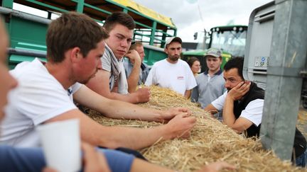 Des agriculteurs discutent sur le barrage qu'ils ont install&eacute; &agrave; proximit&eacute; de Caen, mercredi 21 juillet.&nbsp; (CHARLY TRIBALLEAU / AFP)