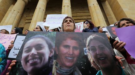 A Beyrouth, au Liban, des femmes tiennent des portraits de victimes de violences conjugales, &agrave; l'occasion de&nbsp;la Journ&eacute;e internationale des droits des femmes, samedi 8 mars 2014.&nbsp; (ANWAR AMRO / AFP)