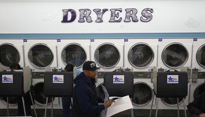 Un électeur tient son bulletin avant d'aller voter dans une laverie de Chicago (Illinois), le 8 novembre 2016. (JIM YOUNG / REUTERS)