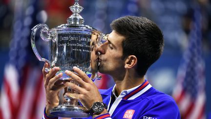 Novak Djokovic embrasse le troph&eacute;e de l'US Open, le 13 septembre 2015, &agrave; New York (Etats-Unis). (JEWEL SAMAD / AFP)