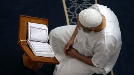 Un homme lit le Coran dans une mosquée pendant le mois sacré du Ramadan à Alger, en Algérie, le 27 mai 2018. (Billal Bensalem / NurPhoto)