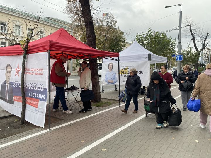 Une équipe du candidat pro-russe Alexander Stoianoglo distribue des tracts de campagne dans une rue de Chisinau (Moldavie), le 17 octobre 2024, juste à côté de celle de la présidente sortante, Maia Sandu. (RAPHAEL GODET / FRANCEINFO)