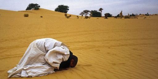 Un musulman en train de prier pendant la prière du soir, quelque part dans le désert de l'Adrar en Mauritanie (18-1-2013) (AFP - Only France - Eric Beracassat)