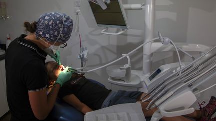 Un dentiste soigne une enfant, le 28 juin 2023, à Briançon (Hautes-Alpes). (THIBAUT DURAND / HANS LUCAS / AFP)