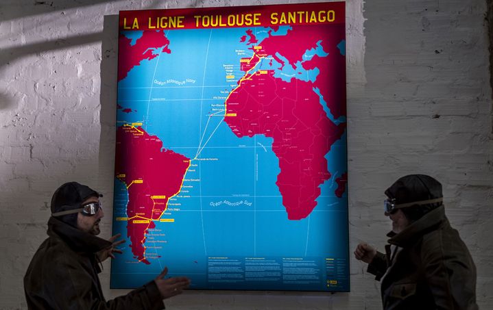 Tenues de pilotes à l'ancienne devant une carte de la ligne Toulouse-Santiago au musée L'Envol des Pionniers, le 18 décembre à Toulouse
 (Éric Cabanis / AFP)