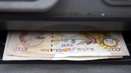 Des billets de livres sterlings dans un distributeur de la capitale britannique, Londres, le 22 octobre 2015. (NIKLAS HALLE'N / AFP)