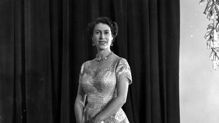 Elizabeth II le jour de son couronnement, le 4 juin 1953. "Elle a porté cette robe le jour de son couronnement et lorsqu'elle a fait l'ouverture des autres parlements; Elle est allé en Océanie : c'est une grande première. A cette époque la reine inspire les jeunes femmes : elle est aussi jeune, elle est glamour. C'est la première fois que les autraliens voient la souveraine. Donc toutes les autraliennes se demandaient ce qu'elle allait porter.&nbsp; (CENTRAL PRESS / HULTON ROYALS COLLECTION)