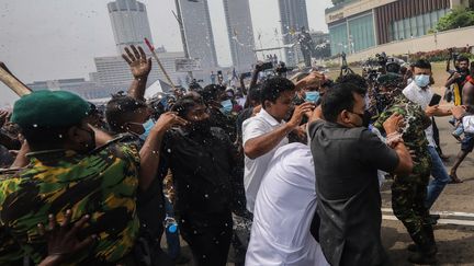 Des agents de sécurité tentent de protéger le chef de l'opposition du Sri Lanka, Sajith Premadasa (non visible), d'une attaque de manifestants près du secrétariat présidentiel à Colombo, au Sri Lanka, le 9 mai 2022.&nbsp; (CHAMILA KARUNARATHNE / EPA)