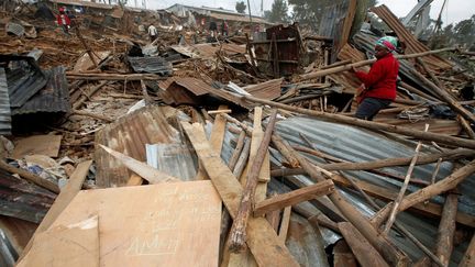 Les habitants, dont les recours en justice ont été rejetés, ne se sont vu offrir aucune solution de rechange. Entre 20 et 30.000 d'entre eux se retrouvent à la rue. Certains tentent de récupérer quelques morceaux de bois et plaques de tôle pour reconstituer un abri ailleurs. «Que Dieu bénisse ma maison», peut-on lire sur un panneau. (Baz RATNER / REUTERS)