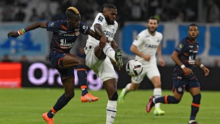 Le Montpelliérain Falaye Sacko au duel avec le Marseillais Nuno Tavares, le 31 mars 2023, lors de la 29e journée de Ligue 1. (NICOLAS TUCAT / AFP)