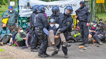 Les forces de l'ordre évacuent des militants qui bloquaient une route d'accès à l'usine Tesla à Grünheide (Allemagne), le 10 mai 2024. (PATRICK PLEUL / DPA VIA AFP)