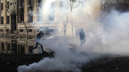 Des manifestants &eacute;gyptiens fuient les gaz lacrymog&egrave;nes lanc&eacute;s par la police le 4 f&eacute;vrier 2012 au Caire (Egypte). (MAHMUD HAMS / AFP)