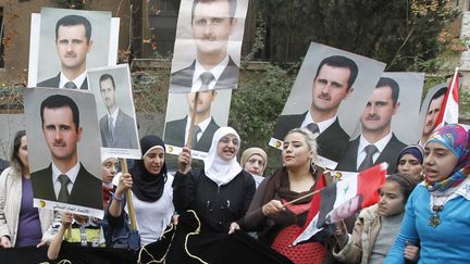 Des femmes manifestent pour soutenir le pr&eacute;sident syrien Bachar Al-Assad &agrave; Damas (Syrie), le 8 mars 2014. ( KHALED AL HARIRI / REUTERS)