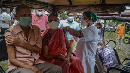 Une soignante vaccine des patients à&nbsp;Siliguri (Inde), le 28 juillet 2021. (DIPTENDU DUTTA / AFP)