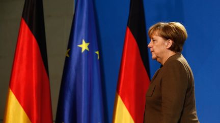 Angela Merkel passe devant les drapeaux allemand et européen, le 23 décembre 2016, à Berlin (Allemagne). (HANNIBAL HANSCHKE / REUTERS)