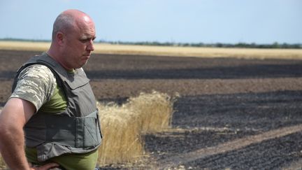 Le commandant Nazar Bogdanovic&nbsp;devant un champ brûlé par les tirs russes dans la région de Kherson (Ukraine) (VALENTIN DUNATE / RADIO FRANCE)