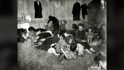 Des femmes et des enfants réfugiés dans une maison le 7 juillet 1944 dans la région de Vire (Normandie). (HULTON ARCHIVE / GALERIE BILDERWELT VIA GETTY IMAGES)