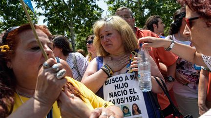 Une mère de famille (au centre) ayant perdu son fils né en 1984, devant un tribunal local de Madrid. (OSCAR DEL POZO / AFP)