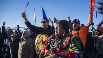 Des manifestants célèbrent le rejet du projet controversé d'oléoduc qui devait traverser les territoires sioux à Cannon Ball, dans le Dakota du Nord (Etats-Unis), le 4 décembre 2016. (JIM WATSON / AFP)