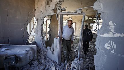 Des hommes inspectent l'intérieur de l'appartement d'un Palestinien soupçonné d'avoir tué deux colons israéliens, après sa destruction par l'armée israélienne, le 19 décembre 2023. (ZAIN JAAFAR / AFP)