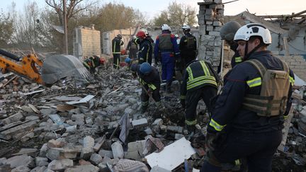 Relief workers after the strike on the village of Groza, eastern Ukraine, October 5, 2023. (ANATOLII STEPANOV / AFP)