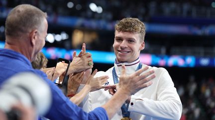 La star française des Jeux de Paris, Léon Marchand, profite avec le public après son quatrième sacre olympique, sur 200 m 4 nages, le 2 août 2024. (COUVERCELLE ANTOINE / AFP)