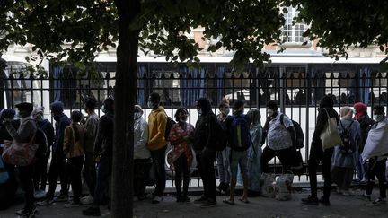 Des personnes sans-abri attendent d'être relogées, à Paris, le 30 juillet (GEOFFROY VAN DER HASSELT / AFP)