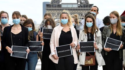 Des personnes tiennent des pancartes "#wearetogether" ("nous sommes ensemble"), le 19 août 2020 au Trocadéro, à Paris. (BERTRAND GUAY / AFP)