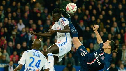 L'attaquant du Paris Saint-Germain, Zlatan Ibrahimovic, aux prises avec le d&eacute;fenseur marseillais, Benjamin Mendy, le 9 novembre 2014. (MIGUEL MEDINA / AFP)