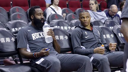 Les joueurs des Rockets James Harden et Russell Westbrook sur le banc d'un match de pré-saison contre Shangai, le 30 septembre 2019. (BOB LEVEY / GETTY IMAGES NORTH AMERICA / AFP)