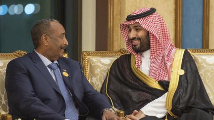 Le prince héritier saoudien, Mohammed ben Salman, en conversation avec le général Abdel Fattah al-Burhan, président du Conseil militaire transitoire au pouvoir au Soudan, lors d'une réunion au sommet de l'Organisation de la conférence islamique (OCI), dans la ville sainte saoudienne de La Mecque le 1er juin 2019. (BANDAR AL-JALOUD / SAUDI ROYAL PALACE)