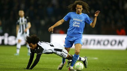 Le milieu de terrain de l'OM&nbsp;Matteo Guendouzi au duel avec le joueur du PAOK Salonique&nbsp;Diego Biseswar, lors du quart de finale retour de Ligue Europa conférence, le 14 avril 2022. (GIANNIS PAPANIKOS / AP)