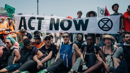 Des militants d'Extinction Rebellion bloquent le pont de Sully, à Paris, le 28 juin 2019. (MATHIAS ZWICK / HANS LUCAS / AFP)