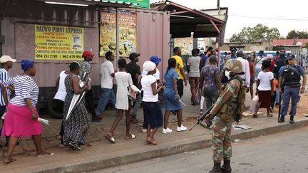 Le 27 mars 2020, l'armée et la police surveillent des habitants d'Alexandra, un township de Johannesburg, venus se ravitailler dans un magasin. (SIPHIWE SIBEKO / X90069)