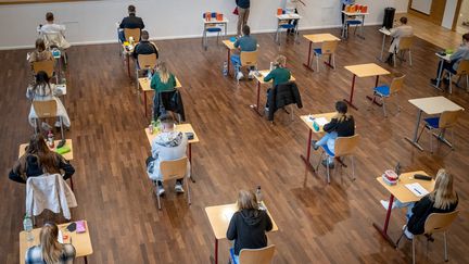 Les élèves d'une école secondaire s'assoient à leur place avant le début de leur examen écrit en histoire,
21 avril 2022, Basse-Saxe, Delmenhorst.  (SINA SCHULDT / DPA)