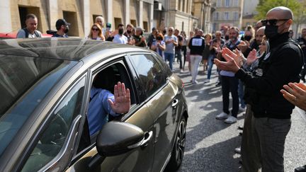 Les officiers de&nbsp;la PJ de Marseille applaudissent et forment une haie d'honneur pour soutenir leur directeur Eric Arella, qui est limogé, le 7 octobre 2022. (NICOLAS TUCAT / AFP)