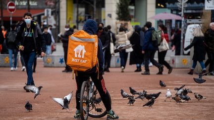 Un livreur de la société Just Eat attend une commande à Lyon, le 2 février 2022. (NICOLAS LIPONNE / HANS LUCAS / AFP)