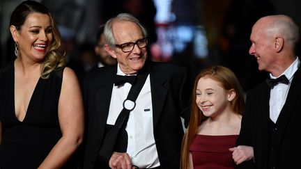 Le cinéaste britannique Ken Loach monte les marches, en compagnie de son équipe, et le bras en écharpe. Le réalisateur a eu&nbsp;19&nbsp;films sélectionnés à Cannes, dont 14 en compétition et 2 Palmes d’or (Le vent se lève en 2006 et Moi, Daniel Blake en 2016). (ALBERTO PIZZOLI / AFP)