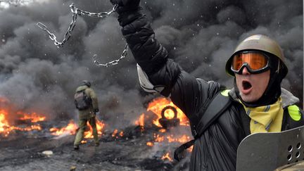 Un manifestant brandit une chaine lors d'affrontements avec la police &agrave; Kiev (Ukraine), le 22 janvier 2014. (SERGEI SUPINSKY / AFP)