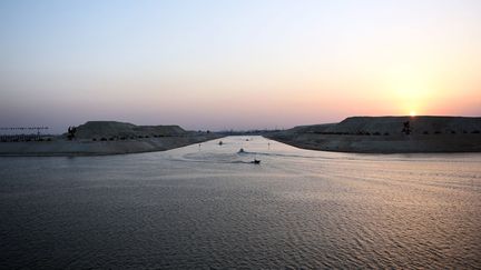 En se dotant d'une nouvelle voie, le canal de Suez devrait voir son trafic doubler, selon l’autorité de gestion du canal de Suez (SCA). L'extension permettra une navigation à double sens et réduira le temps de transit (de dix-huit à onze heures) et d'attente des navires. La moyenne journalière des bateaux qui transitent par le canal «devrait (ainsi) passer de 49 à 97». Quant aux revenus générés, la moyenne annuelle de 5,3 milliards devrait atteindre 13,2 milliards de dollars d'ici à 2023. (MOHAMED EL-SHAHED / AFP)