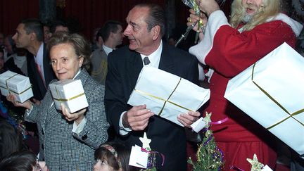 Jacques Chirac &eacute;clipse le P&egrave;re No&euml;l, le 19 d&eacute;cembre 2001.&nbsp;Parmi les enfants, certains viennent d'une &eacute;cole de Toulouse (Haute-Garonne) sinistr&eacute;e par l'explosion de l'usine AZF. D'autres sont scolari&eacute;s dans une &eacute;cole de la Somme, frapp&eacute;e par les inondations. (JOHN SCHULTS / POOL / AFP)