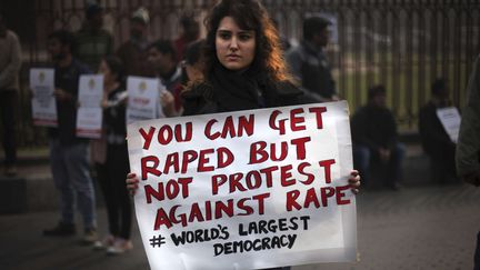 Une manifestante tient une affiche sur laquelle il est &eacute;crit : "Tu peux &ecirc;tre viol&eacute;e, mais pas manifester contre le viol. Plus grande d&eacute;mocratie du monde". New Delhi, le 27 d&eacute;cembre 2012. (ALTAF QADRI / AP / SIPA)