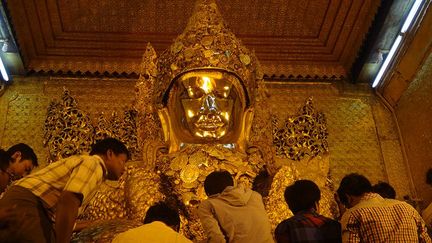 Les temples et leurs statues sont parfois couverts d’or. Au sens propre du terme. A Mandalay, la pagode Mahamuni, sanctuaire le plus sacré de la seconde ville du pays, abrite un bouddha assis qui pèse plus de 6 tonnes. Depuis des décennies, les fidèles y appliquent des feuilles d’or. Aujourd’hui, la couche de métal précieux mesurerait… 15 cm d’épaisseur. 

En l’occurrence, les poseurs de feuilles d’or sont exclusivement masculins. L’activité est interdite aux femmes qui doivent rester en retrait. Et se contenter de regarder ce que font les hommes… sur un écran de télévision. Car la religion bouddhique considère les femmes comme «impures». Celles-ci n’ont pas le droit d’approcher, et encore moins de toucher, les statues sacrées. L’image de tolérance du bouddhisme en prend un coup… (France Télévisions)